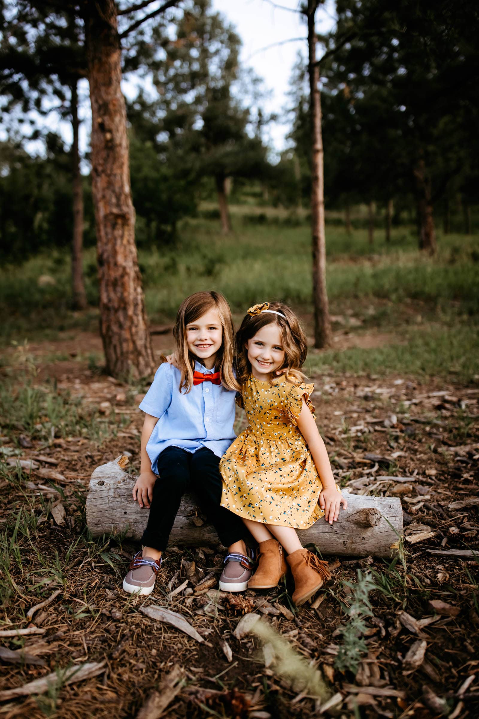 Sisters sitting on a log