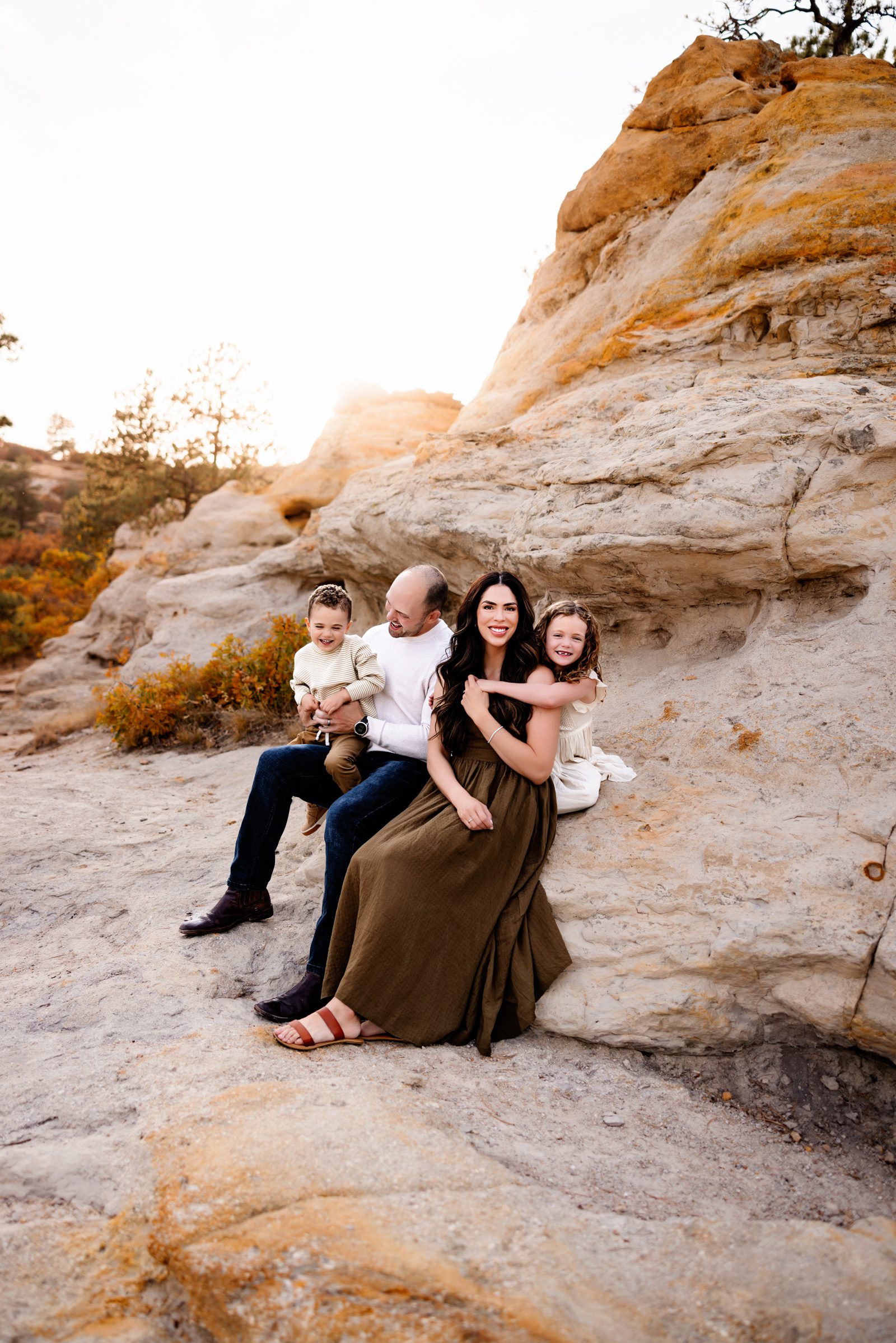 A mother and daughter share a warm embrace on the sunlit trails of a Colorado Springs Outdoor Photography Session.