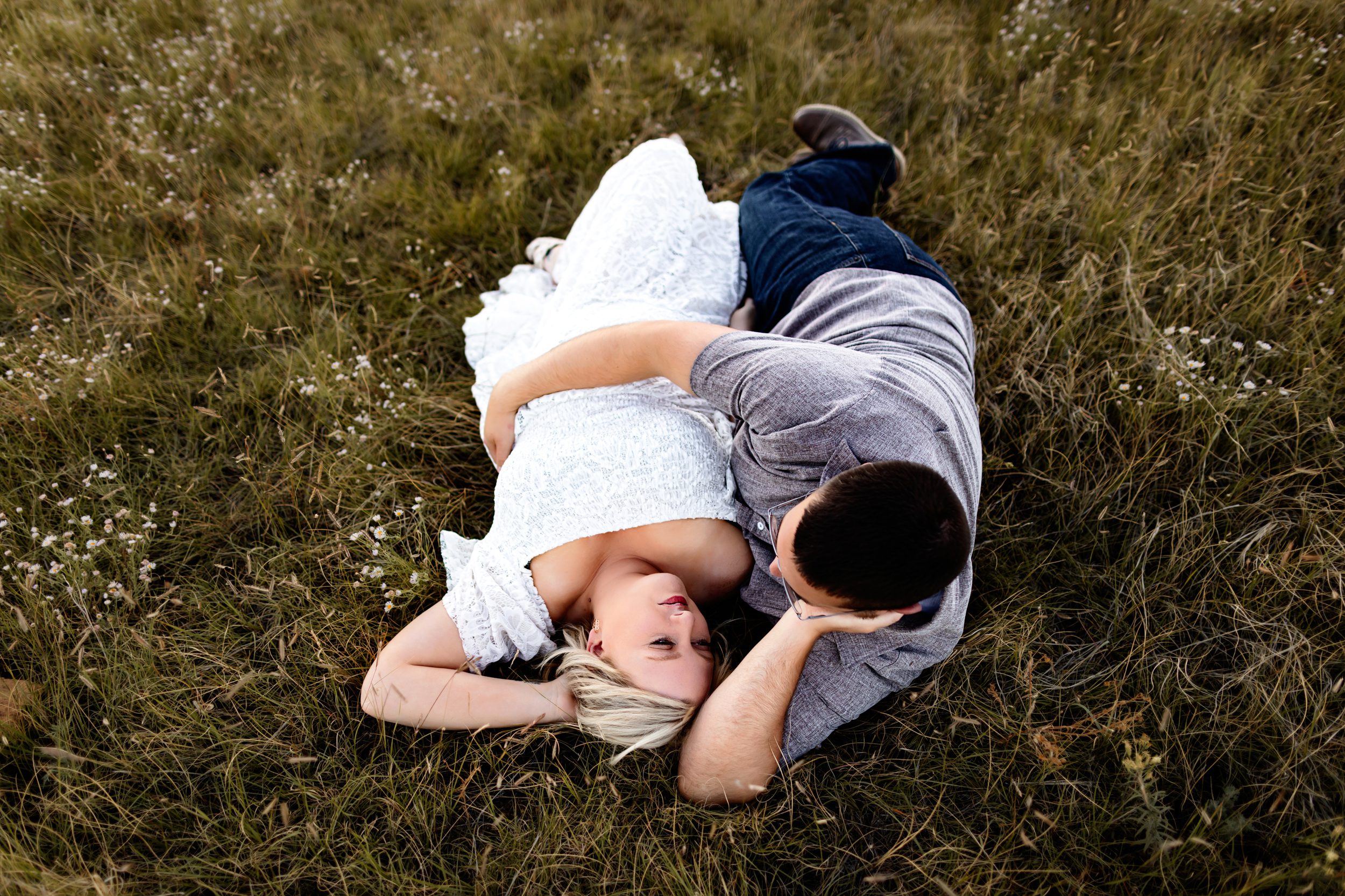 Anniversary Photos in Colorado Springs captured from above as a couple lays in the grass, sharing a quiet and intimate gaze