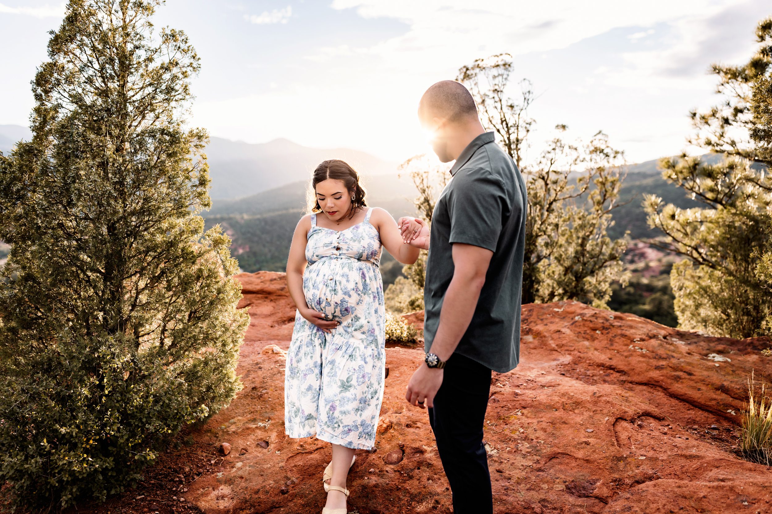 Maternity portrait on red sandstone with golden light during a Colorado Springs outdoor maternity session