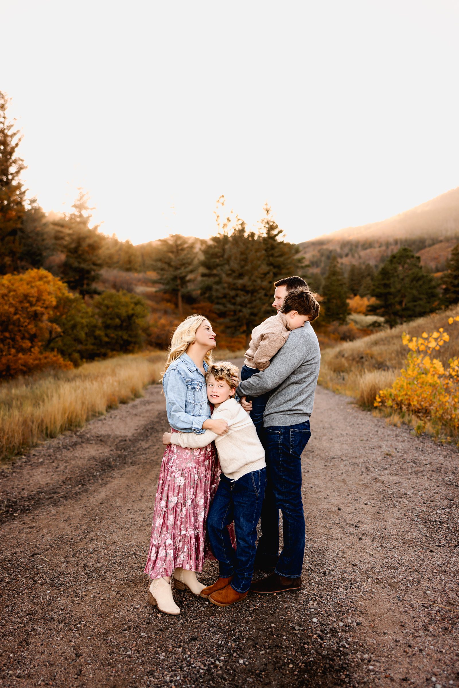 Family of four cuddled together in golden hour light during a Fall Family Mini Session.
