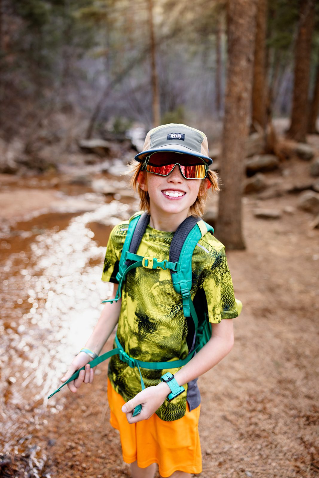 Smiling child enjoying one of the best family friendly hikes in Colorado Springs near a shaded creek.
