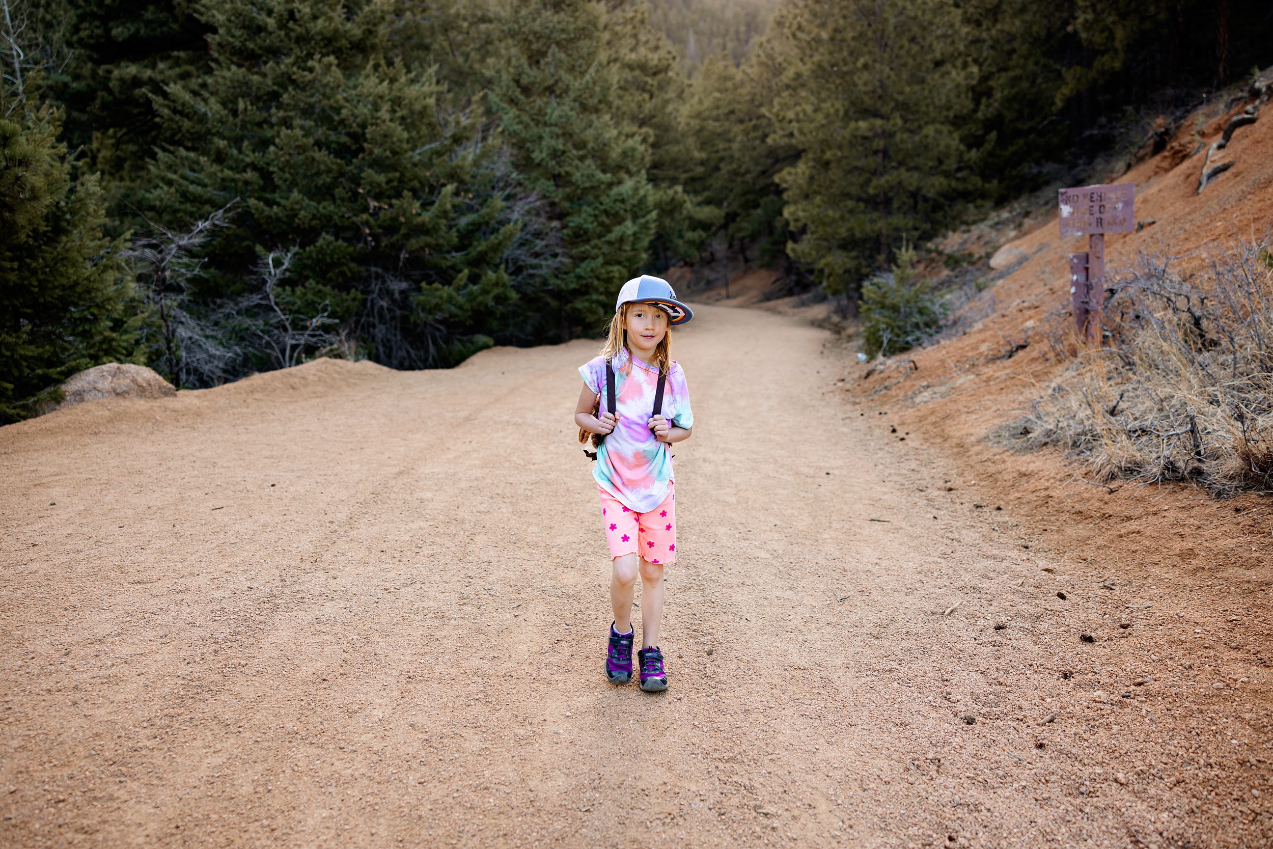 Little girl walking on a sunny mountain path on a scenic family friendly hike in Colorado Springs.