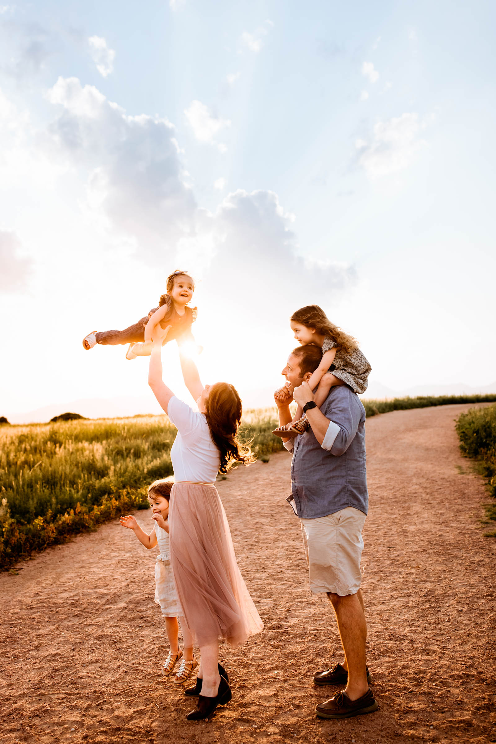 Playful family moment with beautiful sunset behind the family
