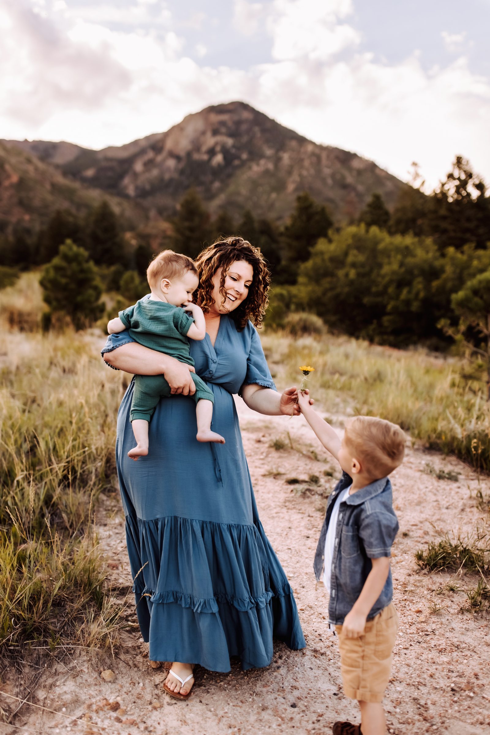 Mom and two boys dressed in shades of blue with the mountains behind them