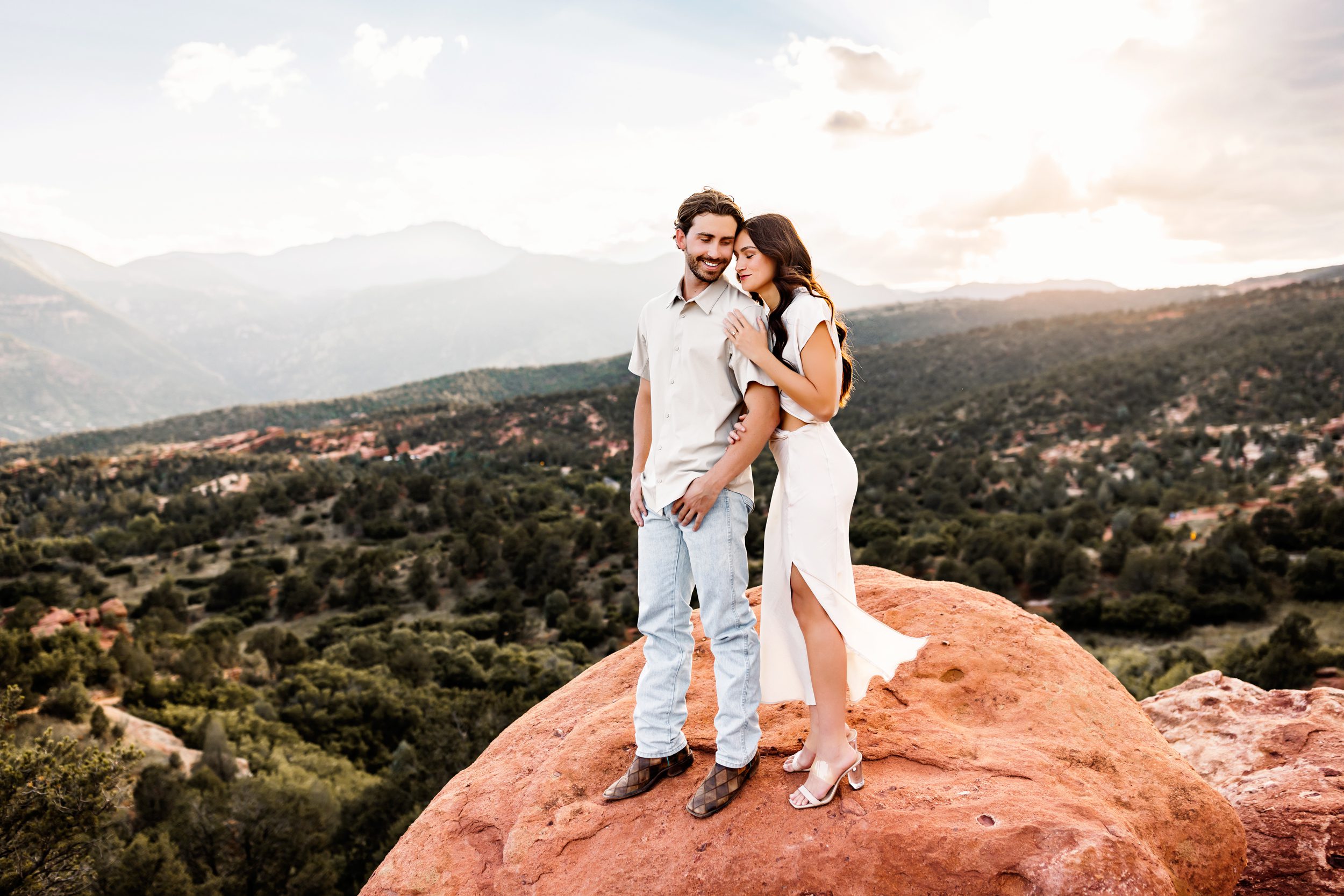 Couple embracing during a sunset couples session at Garden of the Gods with epic mountain views behind them.