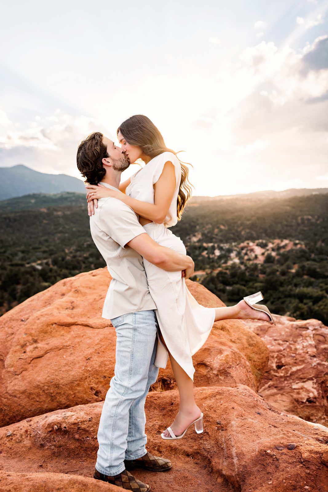 Golden hour kiss with sweeping views and warm light during a mountain photo session.
5.