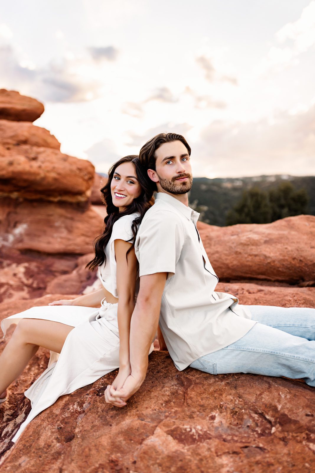 Happy couple posing on red rocks with relaxed, fun energy and warm tones all around.
5.