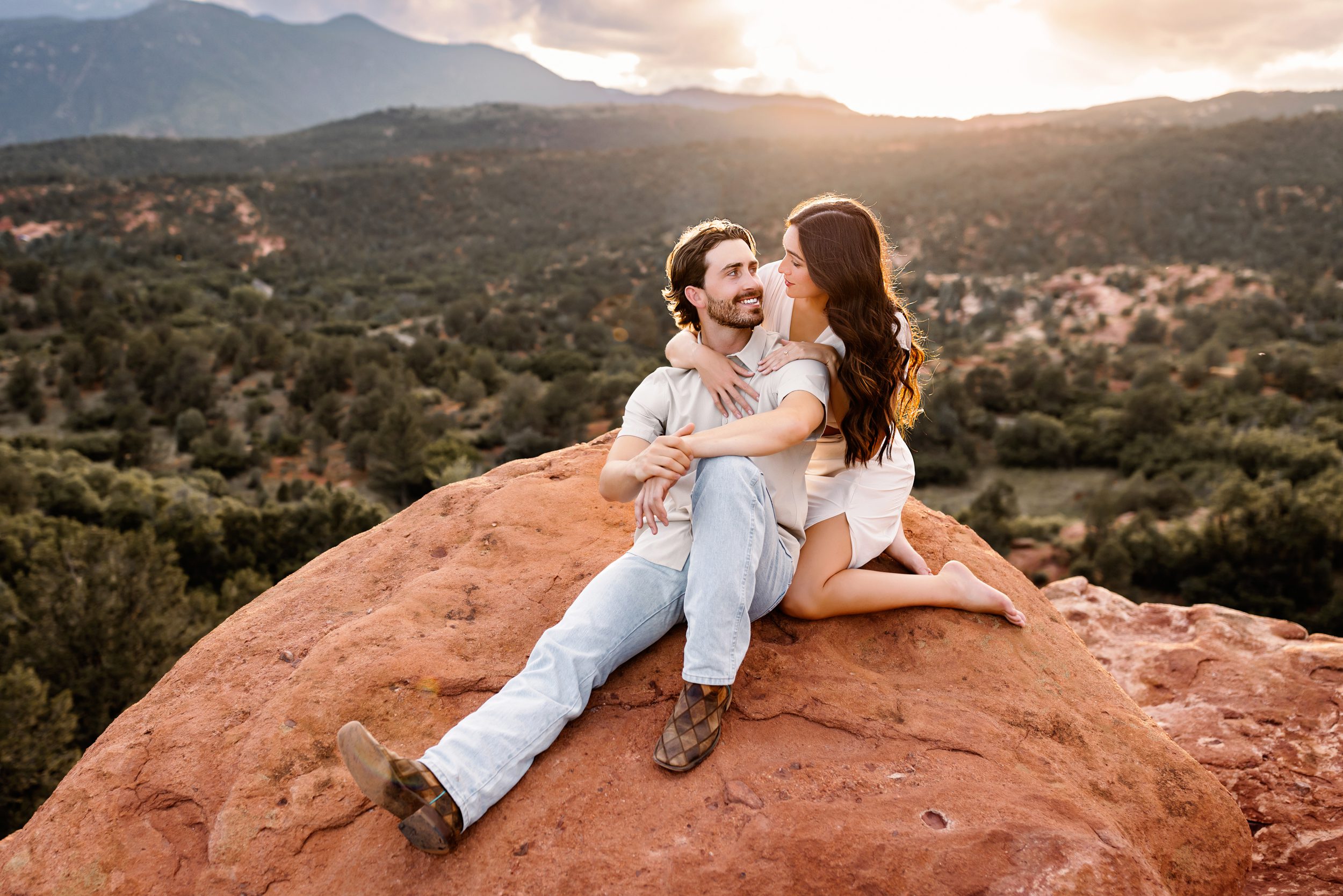 Intimate moment during a couples session at Garden of the Gods with warm sunset skies and bold red rocks.