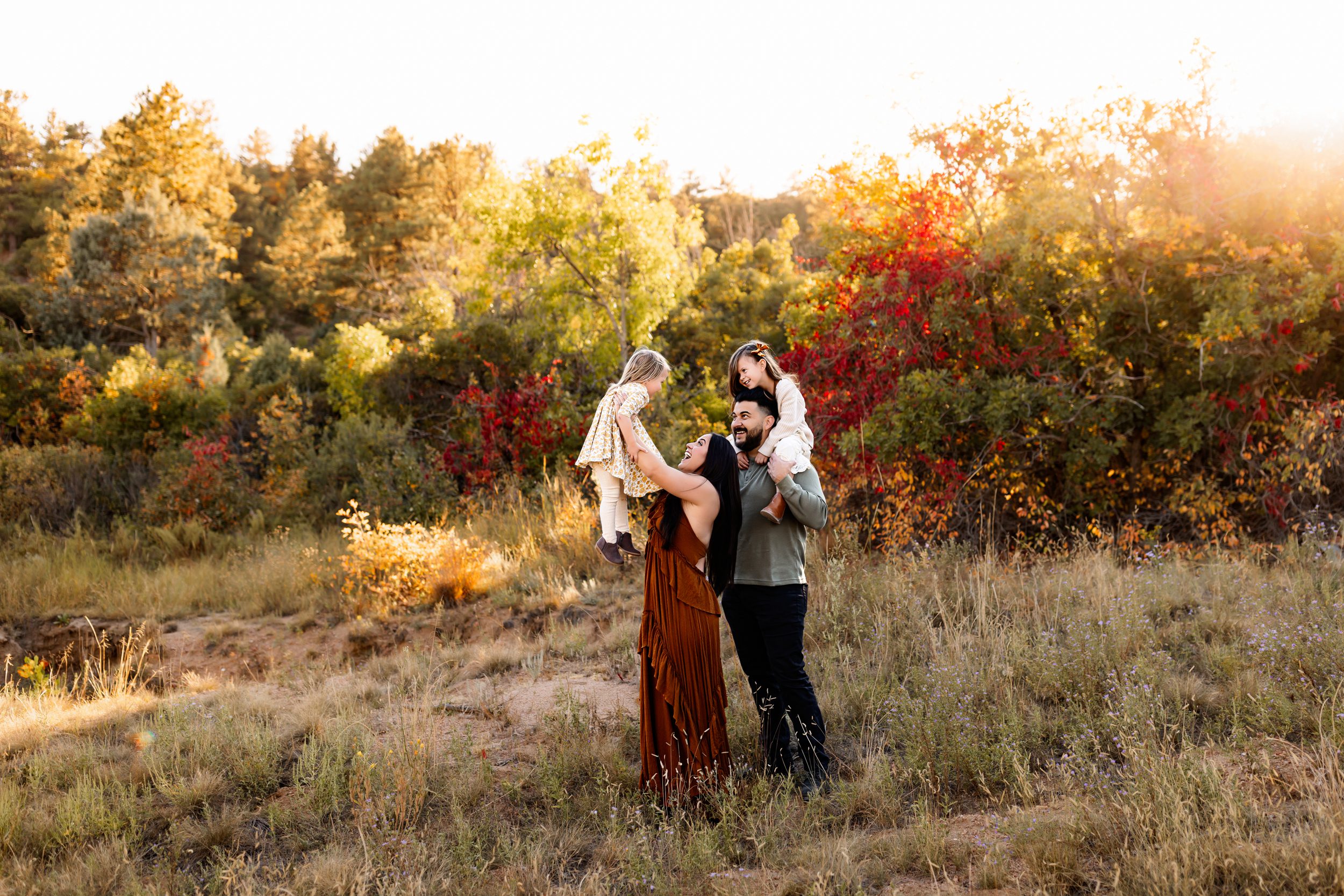 Playful family moment during fall foliage photos in Colorado Springs at golden hour.