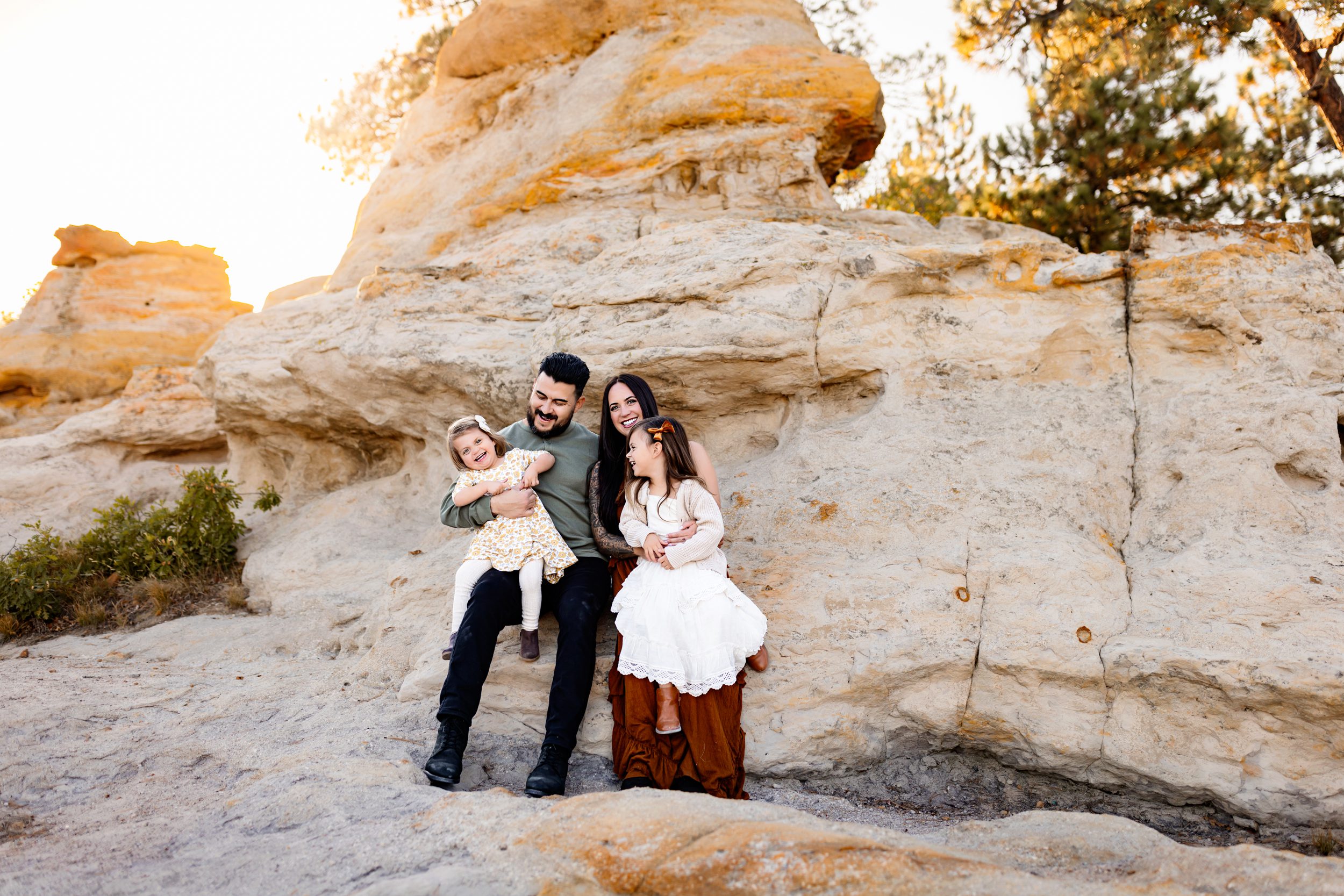 Casual family moment captured on rocky terrain with a beautiful natural backdrop.
