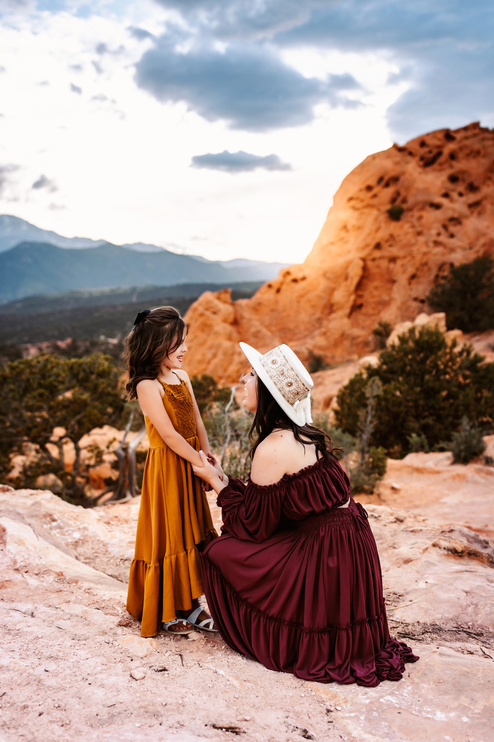 Mom and daughter share a sweet moment during their Family Adventure Session in front of dramatic Colorado rock formations.