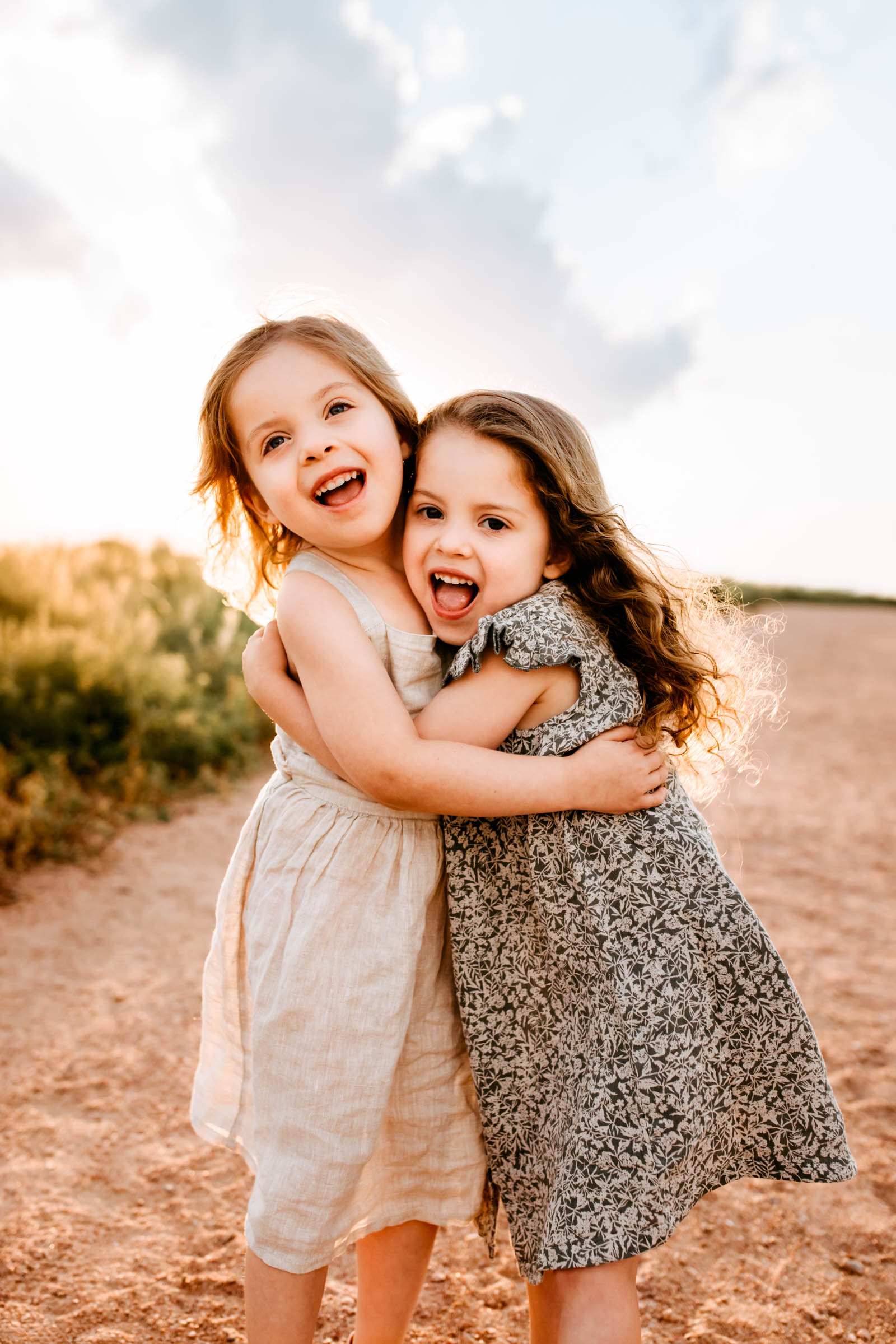 Two sisters sharing a joyful embrace, laughing together during their Colorado Springs Summer Session.