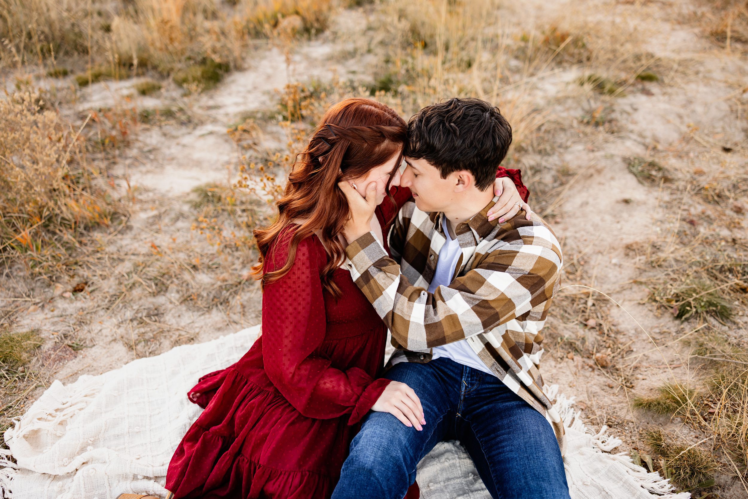 couple sitting on a blanket sharing a quiet, intimate moment
