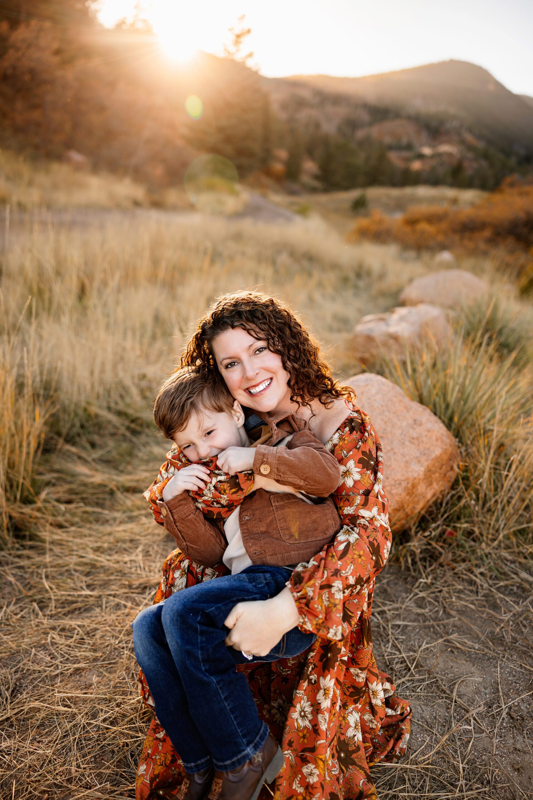 Fall Photo Session in Colorado Springs with mom holding child in golden light surrounded by soft autumn tones