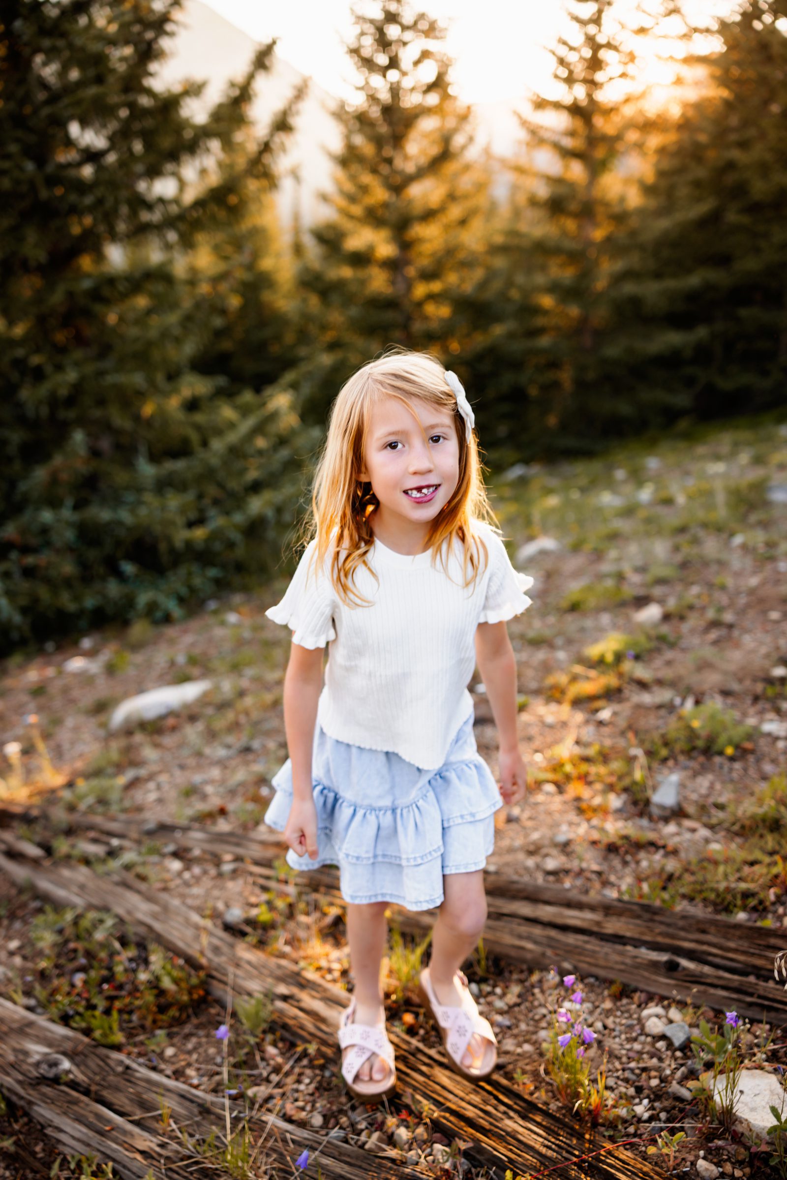 Child exploring wildflowers during Family Photos in Breckenridge with soft mountain sunset light
