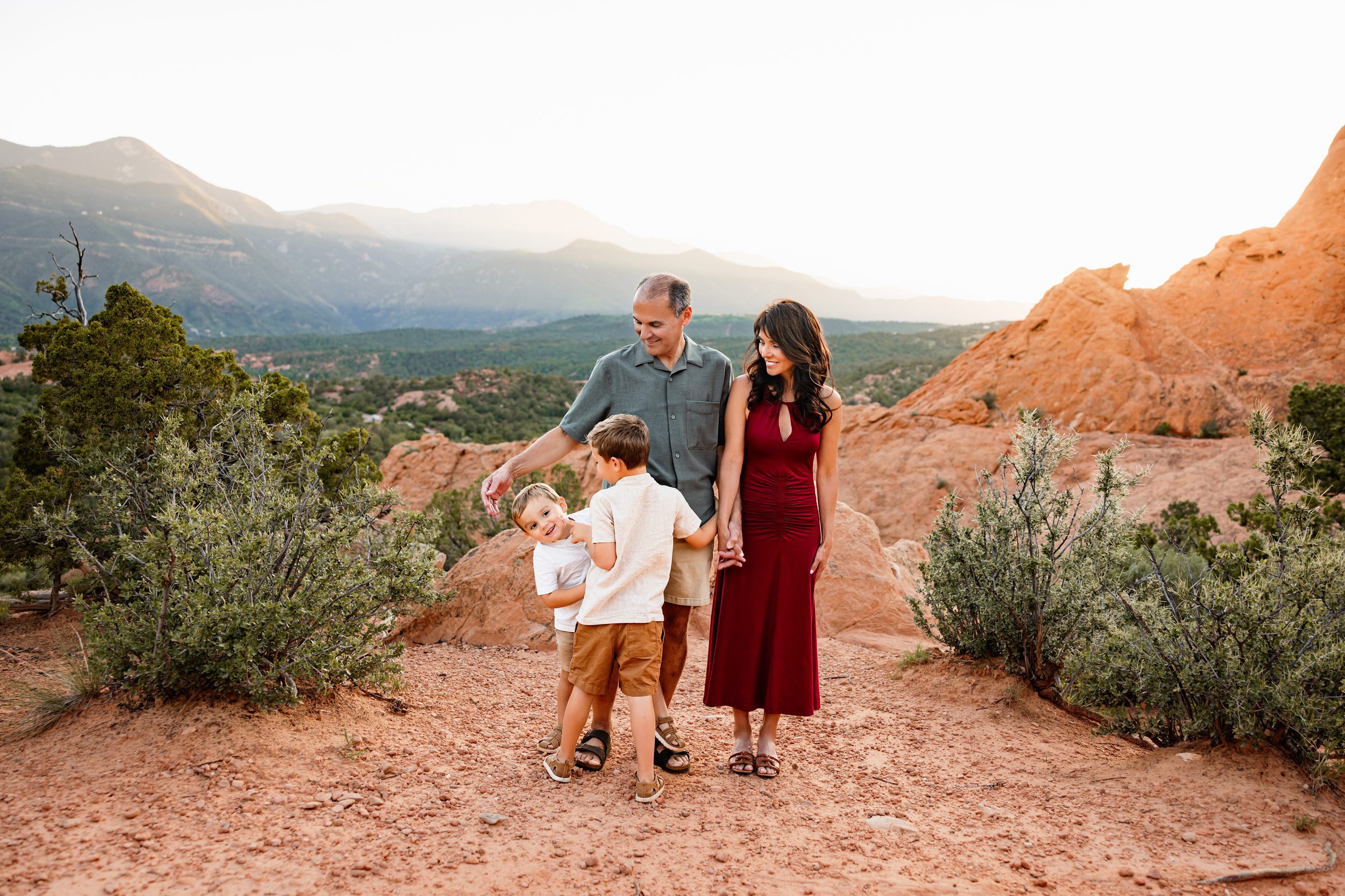 Grandparents holding hands with grandchildren on a red rock trail at Garden of the Gods, including grandparents in your family photos