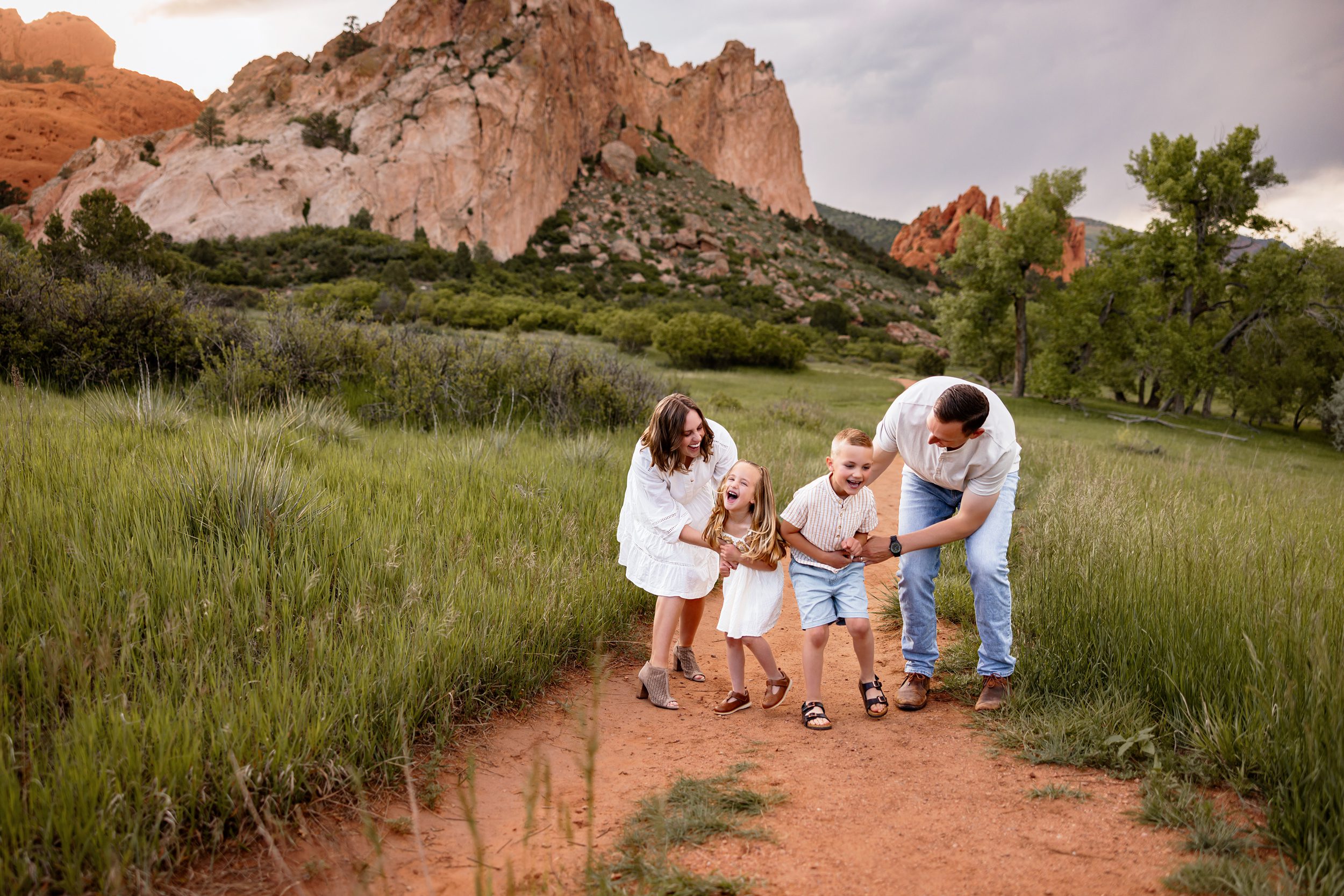 Candid family moment with kids giggling and parents walking along a scenic Colorado trail