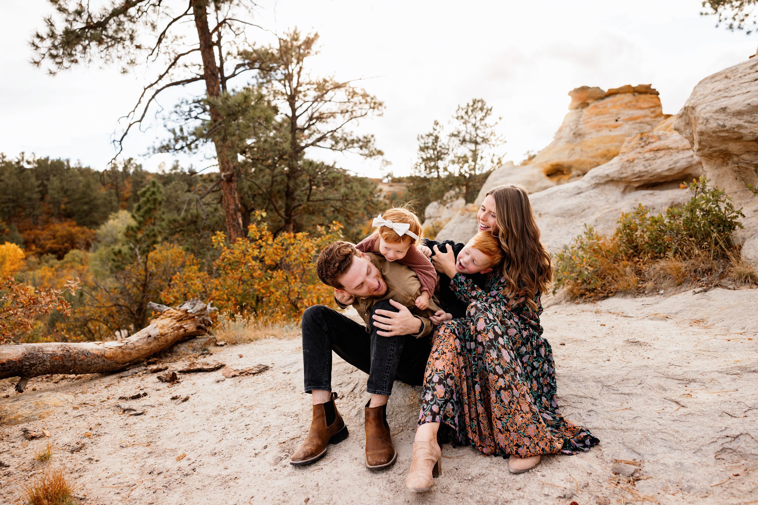 Photo session with toddler in Colorado Springs featuring a family walking hand in hand through a natural trail