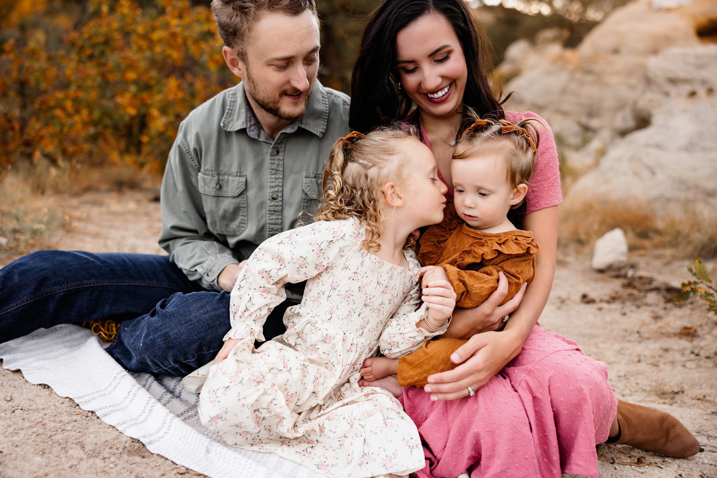 close-up of parents and young children sharing a sweet candid moment together